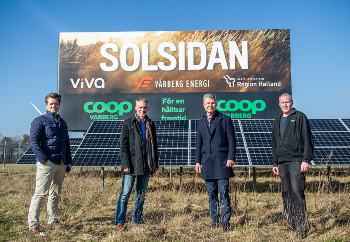 Fyra män som står framför solcellspanel och skylt där det står Solsidan