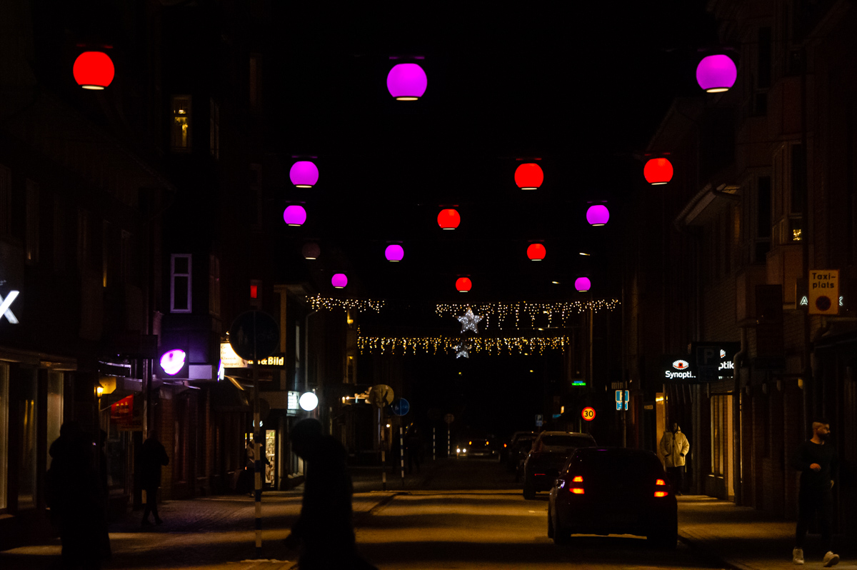 Kvällsbild över halo-lamporna på Östra Långgatan som lyser i rött och rosa
