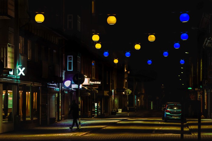 Stadsgata med gul och blå belysning från ett flertal runda lampor