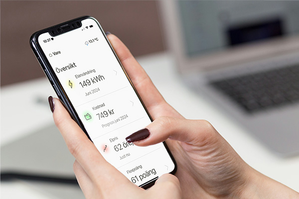 hand med mobil som visar statistik för energi i ett hem